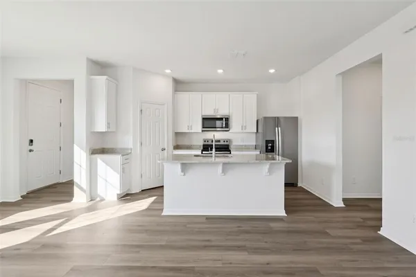 a view of kitchen with stainless steel appliances refrigerator stove microwave and cabinets