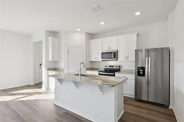 a kitchen with stainless steel appliances a refrigerator stove microwave and sink