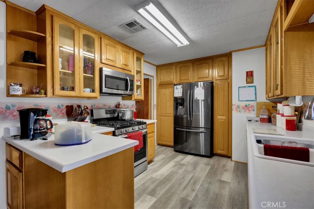 9800 Base Line Road, Unit 114 Rancho Cucamonga, CA 91701 - Photo 16 of 48 a kitchen with a refrigerator and a stove top oven