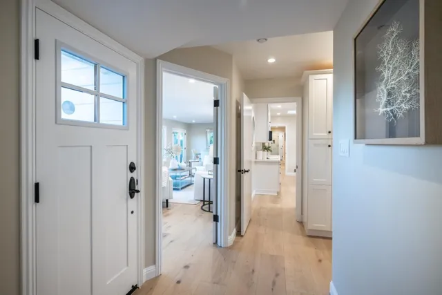 view of a hallway with wooden floor and a bathroom