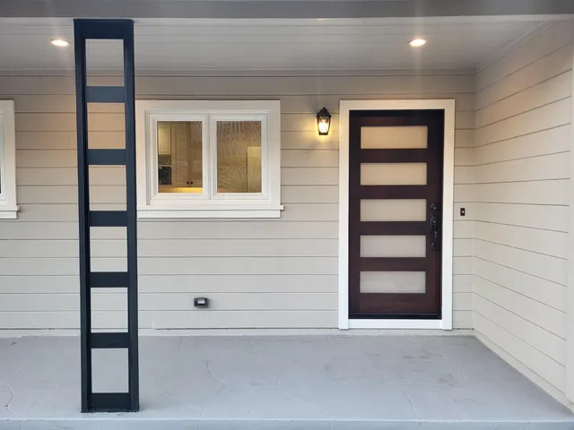 a living room with couch a large window and a fireplace