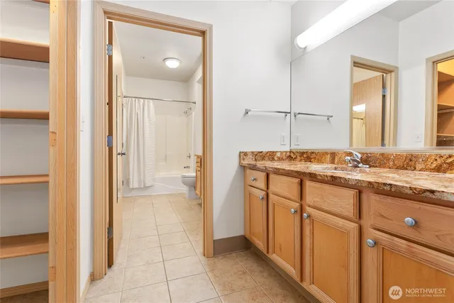 a bathroom with a granite countertop sink and a mirror
