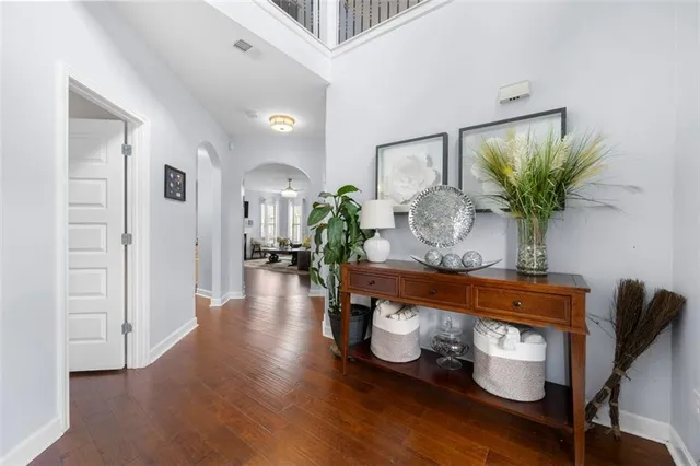 a view of a hallway with wooden floor a glass top table and chairs