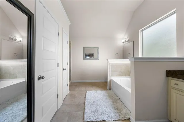 a view of a bathroom with tub and mirror