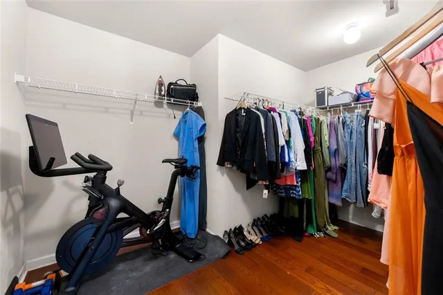 a view of walk in closet with clothes and shoes