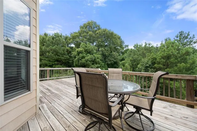 a roof deck with chairs and wooden floor