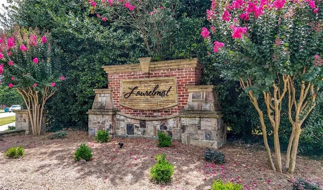 a sign that is sitting in front of a tree