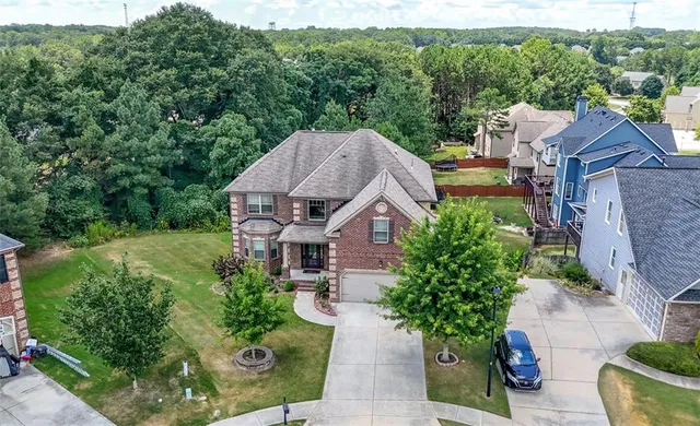 an aerial view of a house with yard and green space