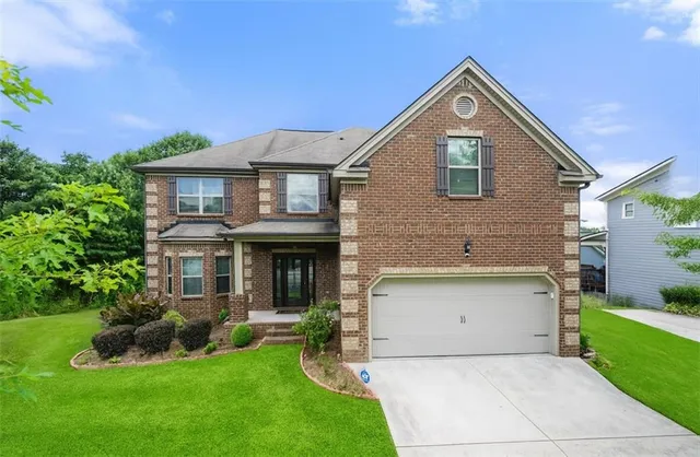 a front view of a house with a yard and garage