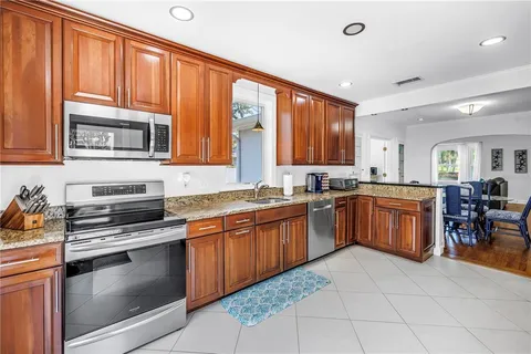 a kitchen with stainless steel appliances granite countertop wooden cabinets a stove top oven a sink and dishwasher