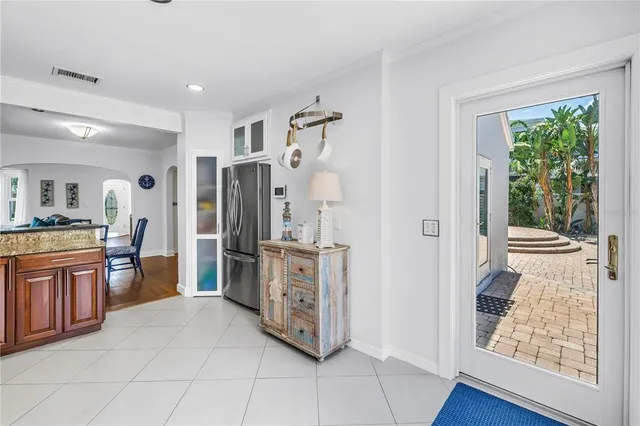 a large white kitchen with stainless steel appliances granite countertop a refrigerator and a stove top oven