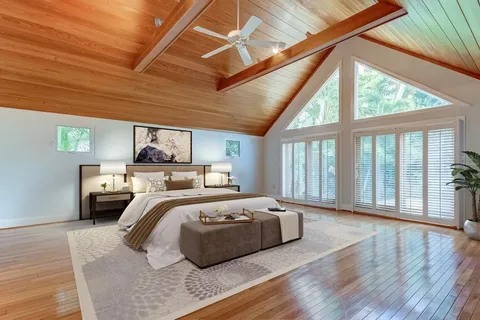 a bedroom with furniture and large windows