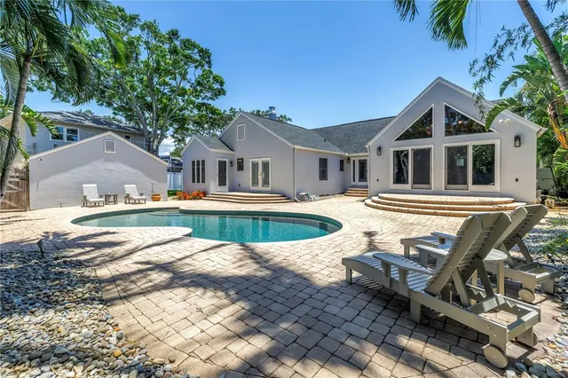 a view of a house with pool and sitting area