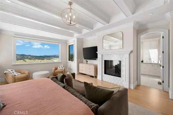 a view of a livingroom with wooden floor and a flat screen tv