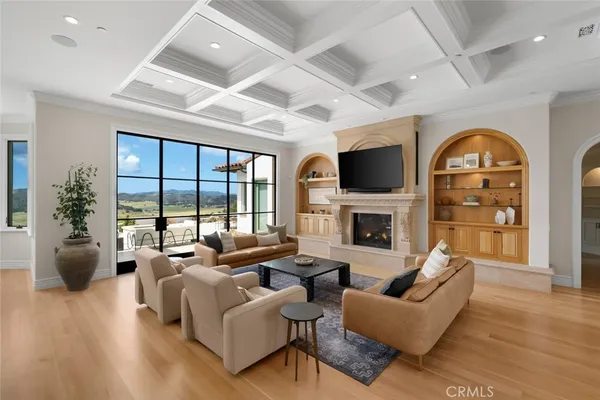 a living room with furniture a large window and a fireplace