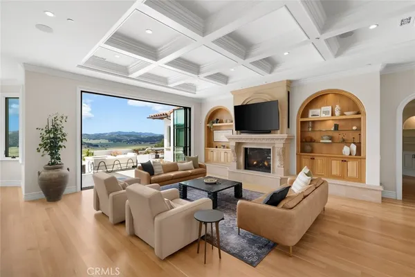 a kitchen with stainless steel appliances kitchen island granite countertop a stove a sink a refrigerator and white cabinets with wooden floor