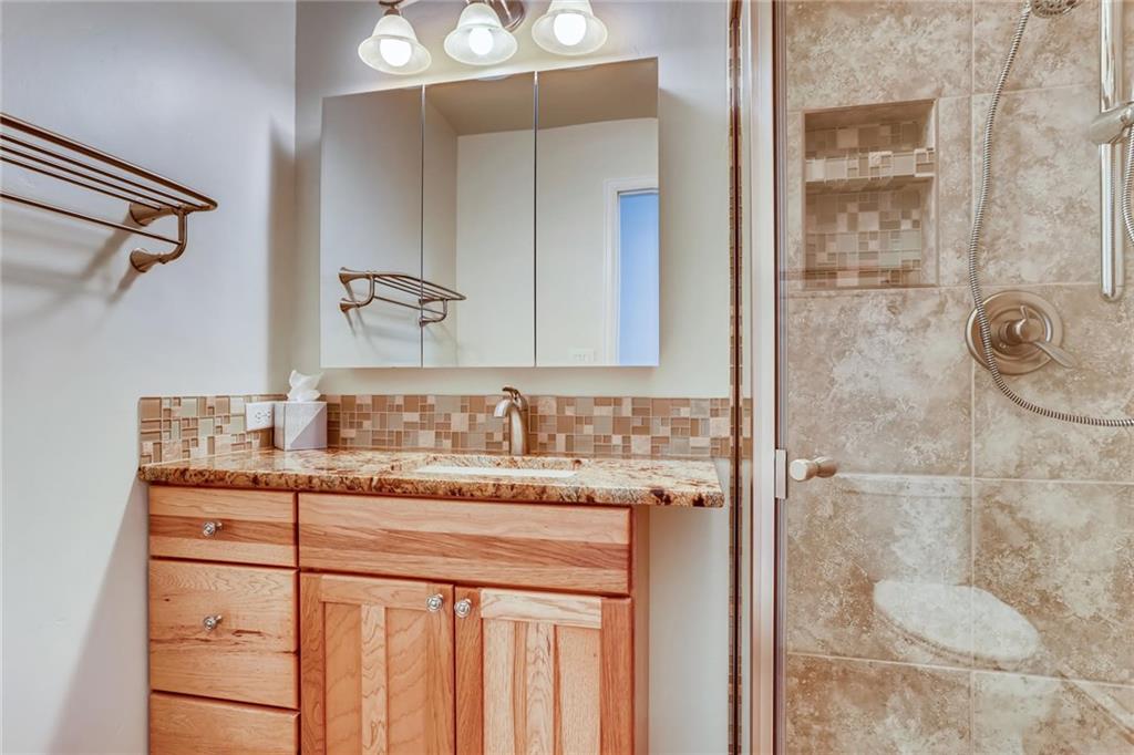 82 Canyon Trail Road Dillon, CO 80435 - Photo 12 of 31 a bathroom with a granite countertop sink a mirror and shower