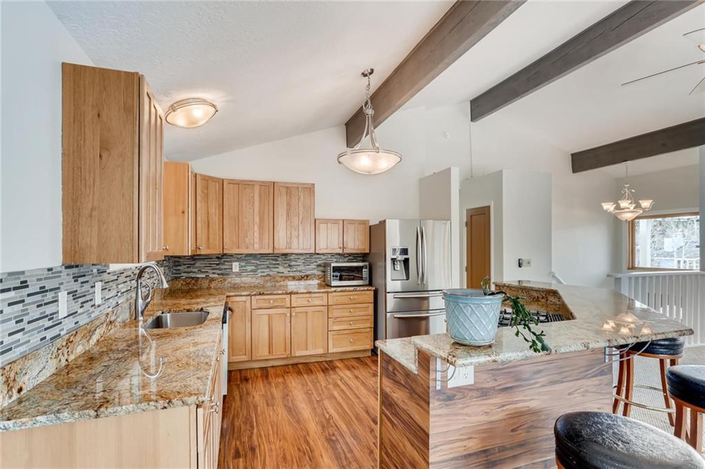 82 Canyon Trail Road Dillon, CO 80435 - Photo 22 of 31 a large kitchen with kitchen island granite countertop wooden cabinets and stainless steel appliances