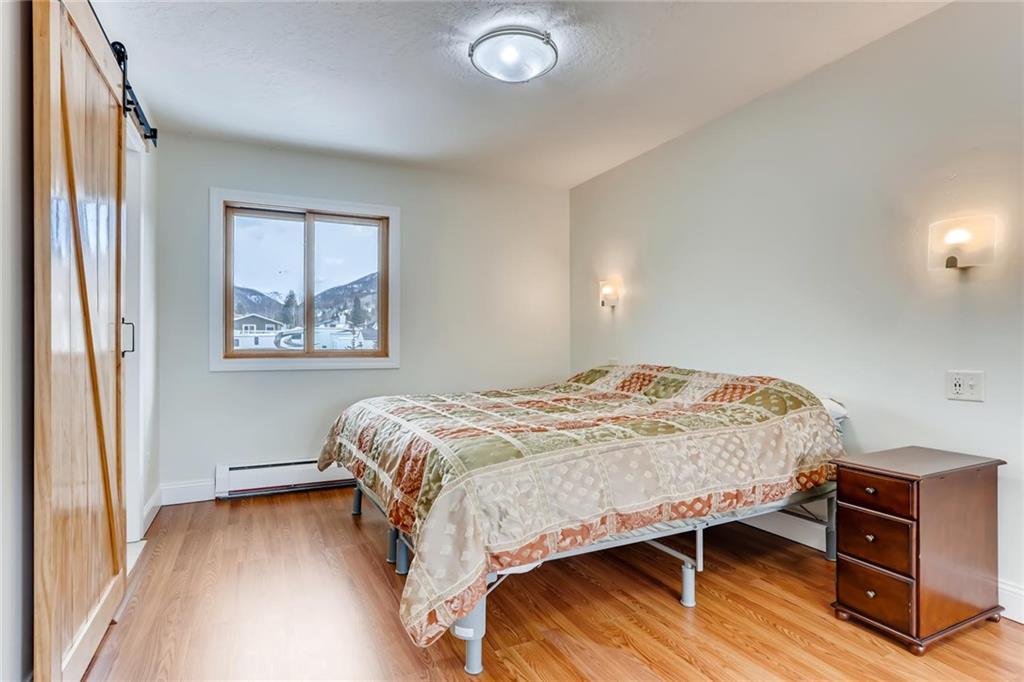 82 Canyon Trail Road Dillon, CO 80435 - Photo 24 of 31 a bedroom with a bed and wooden floor