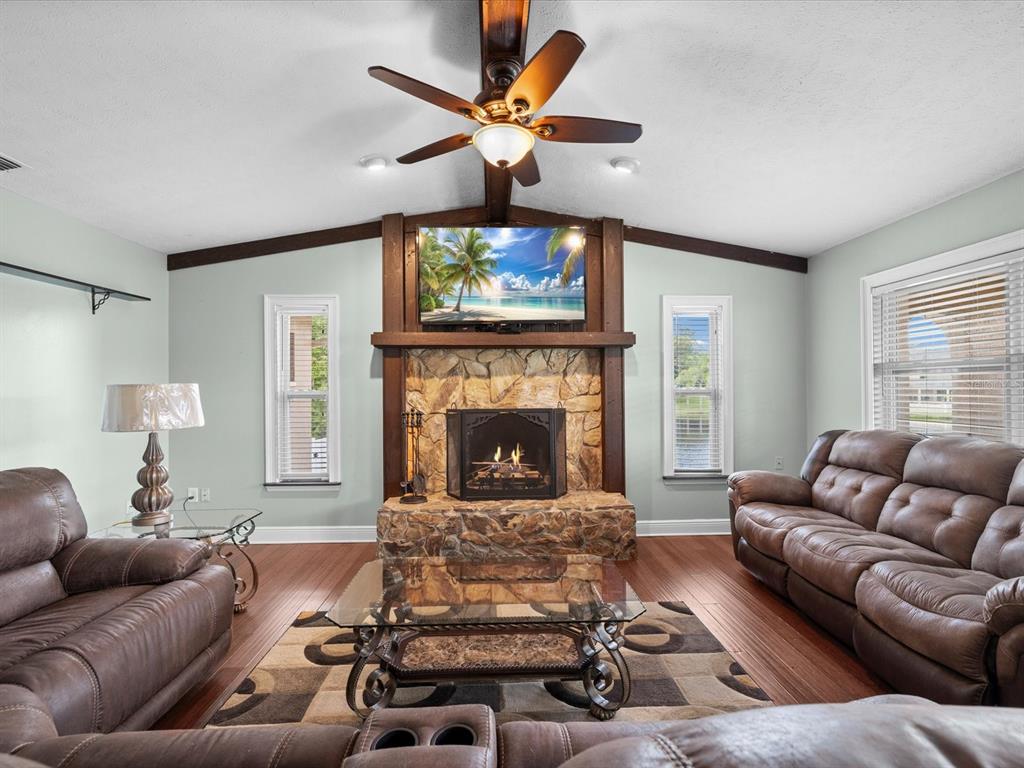 5904 Springrun Court Holiday, FL 34690 - Photo 2 of 53 a living room with furniture a fireplace and a flat screen tv