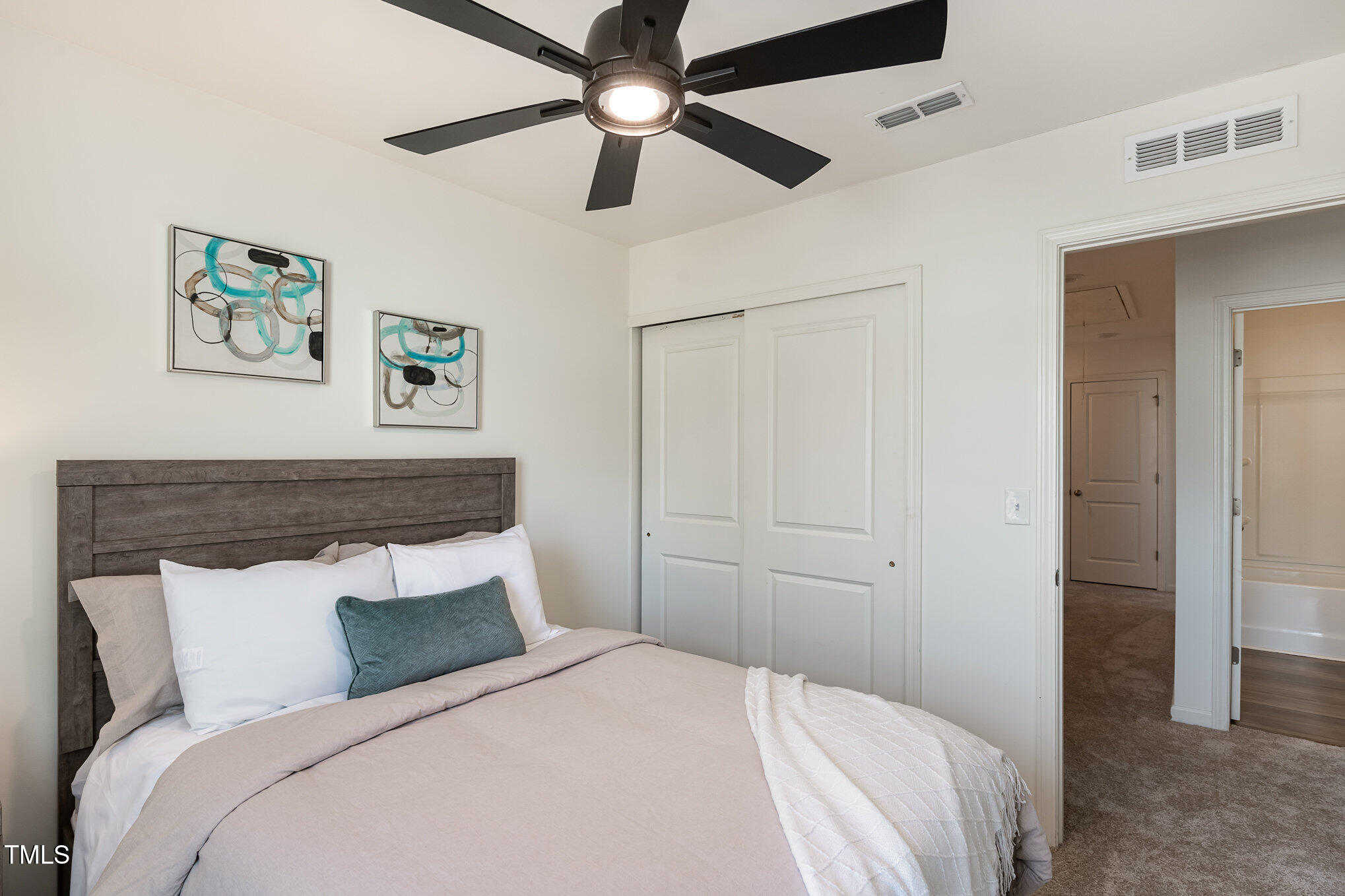 3110 Crater Loop Raleigh, NC 27610 - Photo 25 of 38 a bedroom with a large bed and a chandelier
