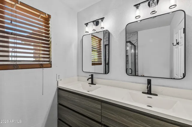 a bathroom with double vanity sinks and a bathtub