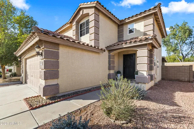 a view of a house with a yard and potted plants