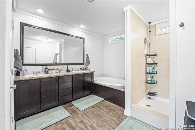 a bathroom with a tub a sink and a large mirror