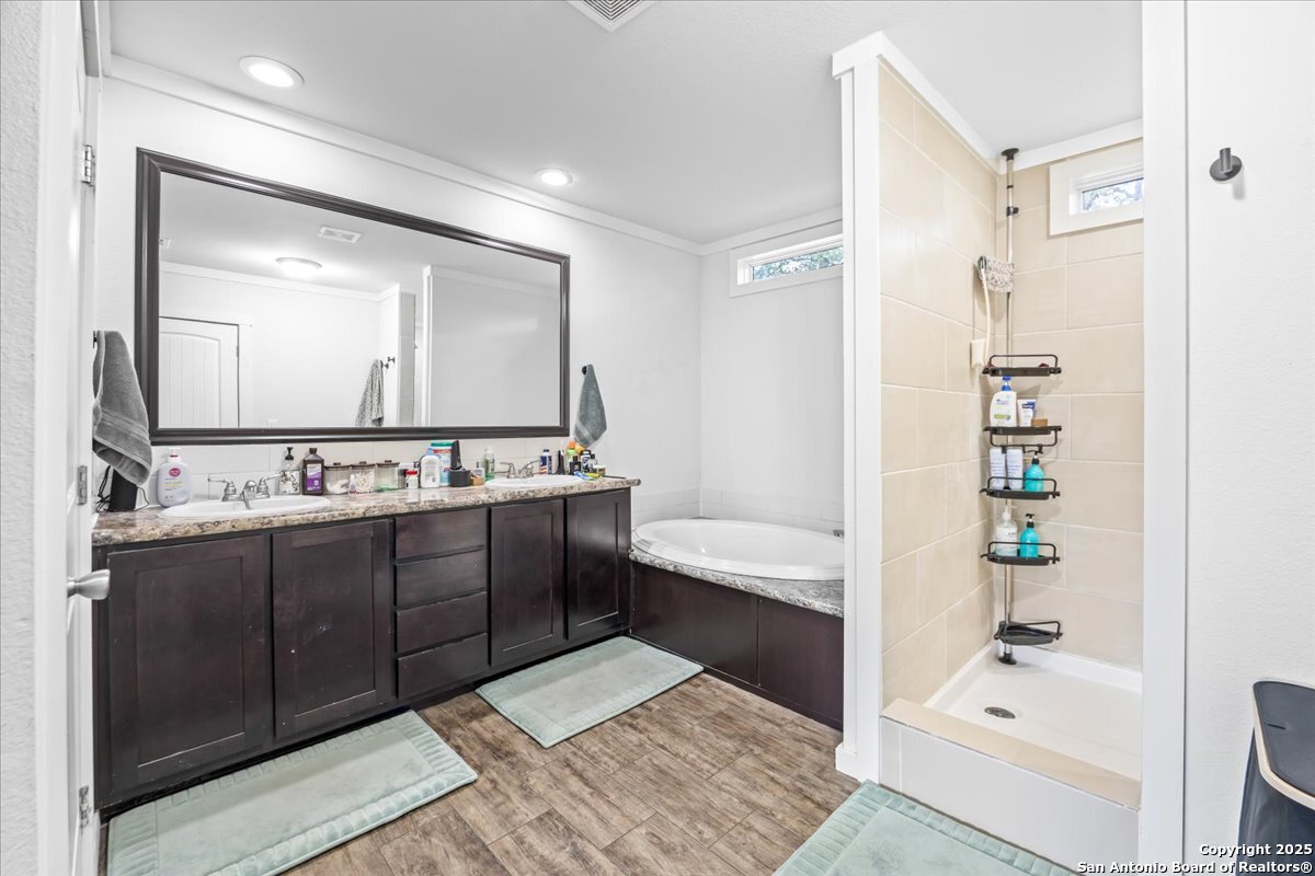 1291 Vivroux Ranch Road Seguin, TX 78155 - Photo 16 of 44 a bathroom with a tub a sink and a large mirror