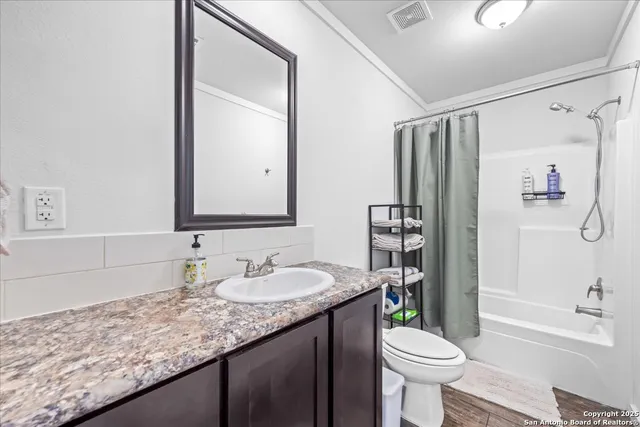 a bathroom with a granite countertop sink toilet mirror and shower
