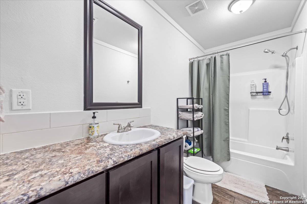 1291 Vivroux Ranch Road Seguin, TX 78155 - Photo 20 of 44 a bathroom with a granite countertop sink toilet mirror and shower