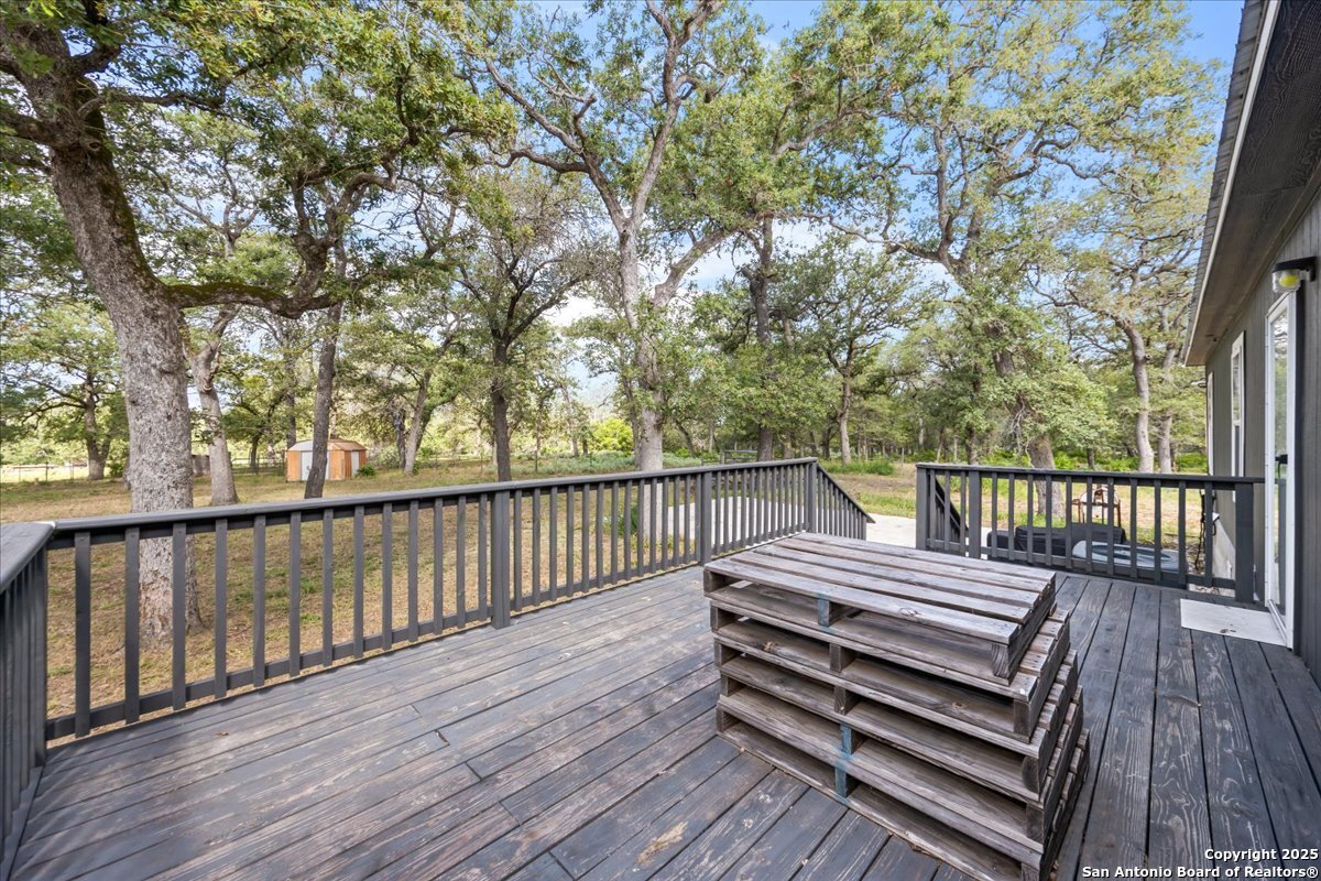 1291 Vivroux Ranch Road Seguin, TX 78155 - Photo 23 of 44 a view of a wooden deck with a bench and trees