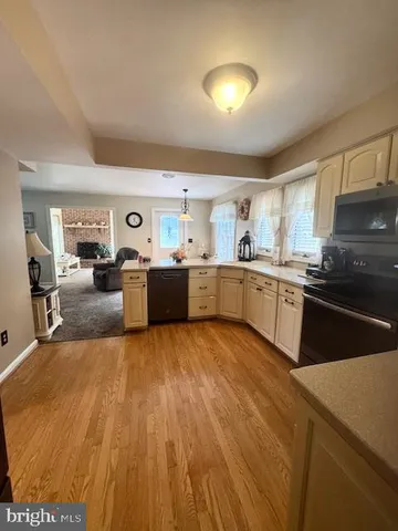 a large kitchen with wooden floors and stainless steel appliances