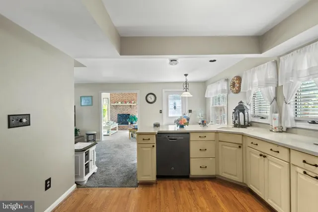 a kitchen with lots of counter top space sink and wooden floor
