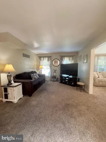 a living room with furniture a window and a lamp