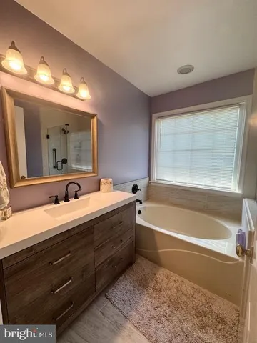 a bathroom with a tub sink and mirror