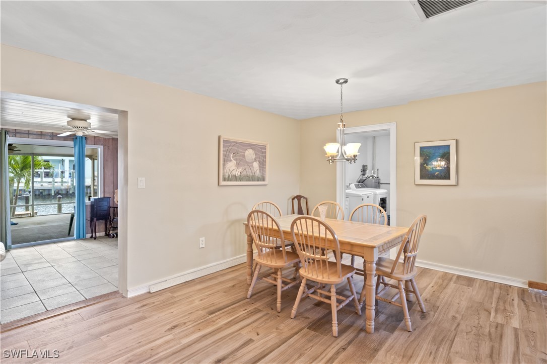 12206 Boat Shell Drive Matlacha Isles, FL 33991 - Photo 12 of 50 a dining room with furniture a chandelier and wooden floor