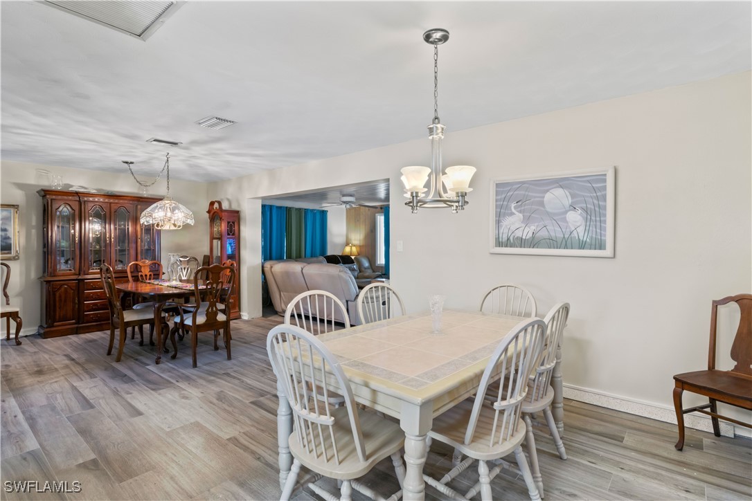 12206 Boat Shell Drive Matlacha Isles, FL 33991 - Photo 14 of 50 a view of a dining room and livingroom with furniture wooden floor a chandelier