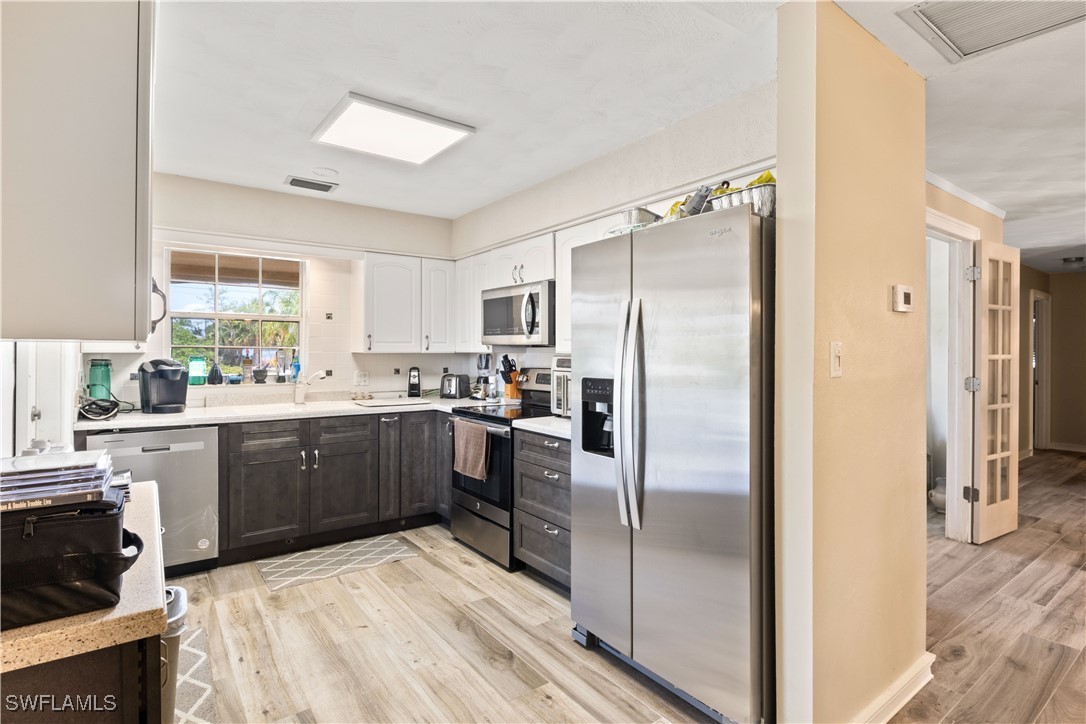 12206 Boat Shell Drive Matlacha Isles, FL 33991 - Photo 16 of 50 a kitchen with a refrigerator a sink a stove and cabinets