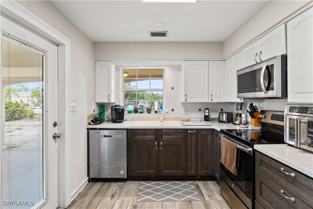 12206 Boat Shell Drive Matlacha Isles, FL 33991 - Photo 18 of 50 a kitchen with a sink stove and cabinets