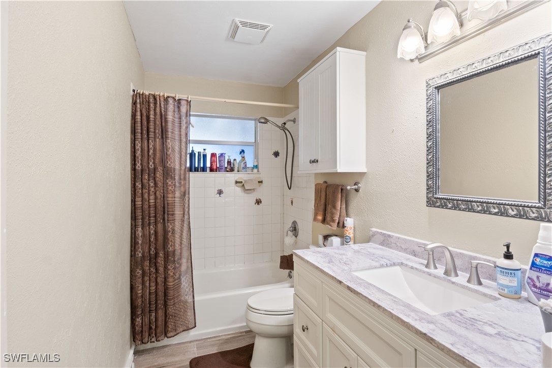 12206 Boat Shell Drive Matlacha Isles, FL 33991 - Photo 21 of 50 a bathroom with a granite countertop sink mirror vanity and toilet