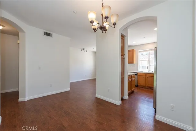 a view of a room with a hardwood floor and a ceiling fan