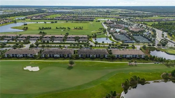 an aerial view of residential houses with outdoor space and ocean view