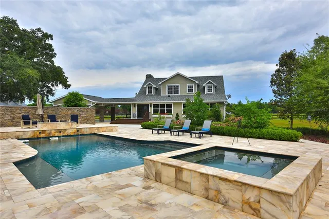 a view of a house with swimming pool and sitting area