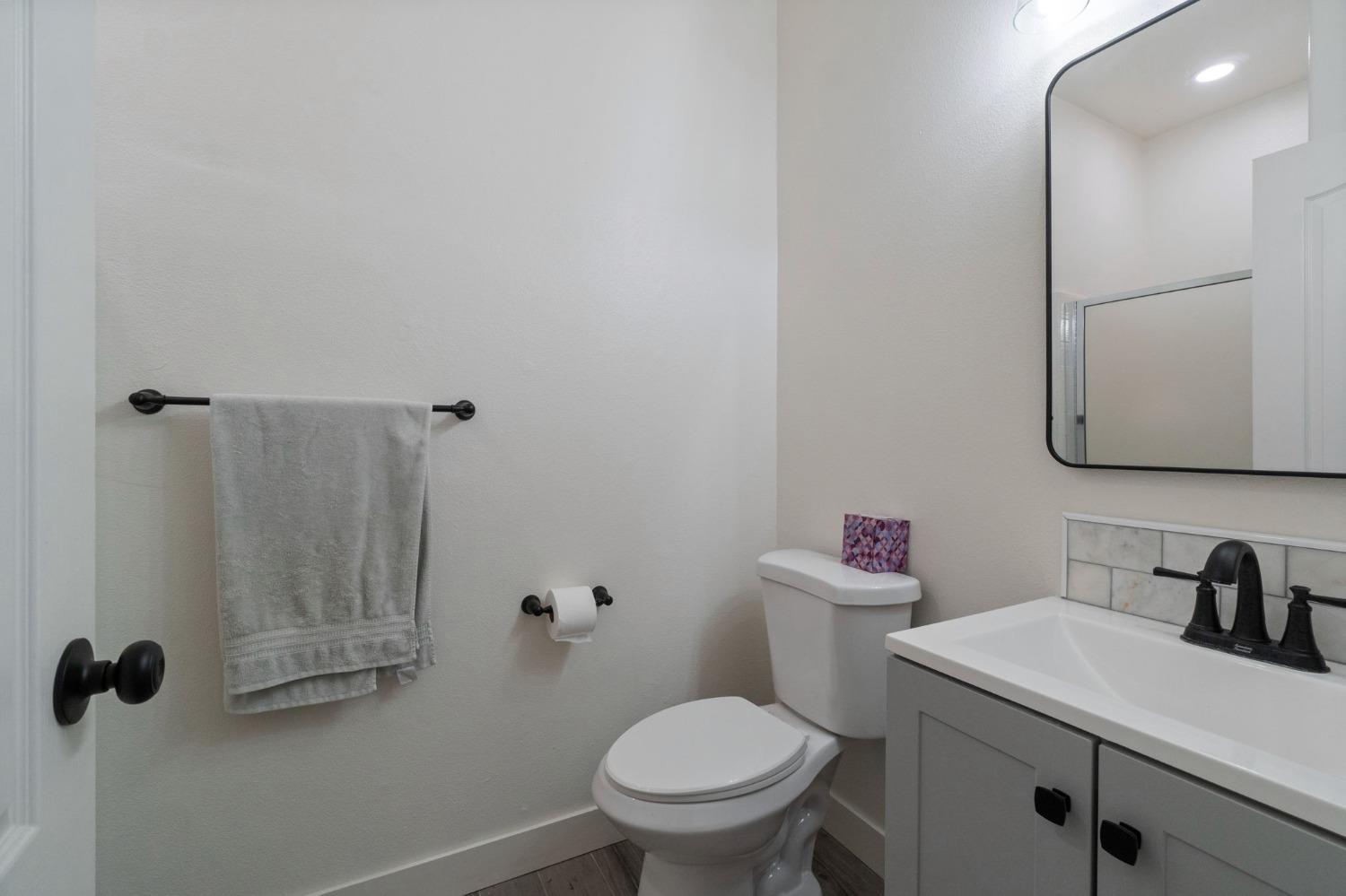 1732 North Avignon Lane Clovis, CA 93619 - Photo 13 of 28 a bathroom with a sink a toilet and a mirror