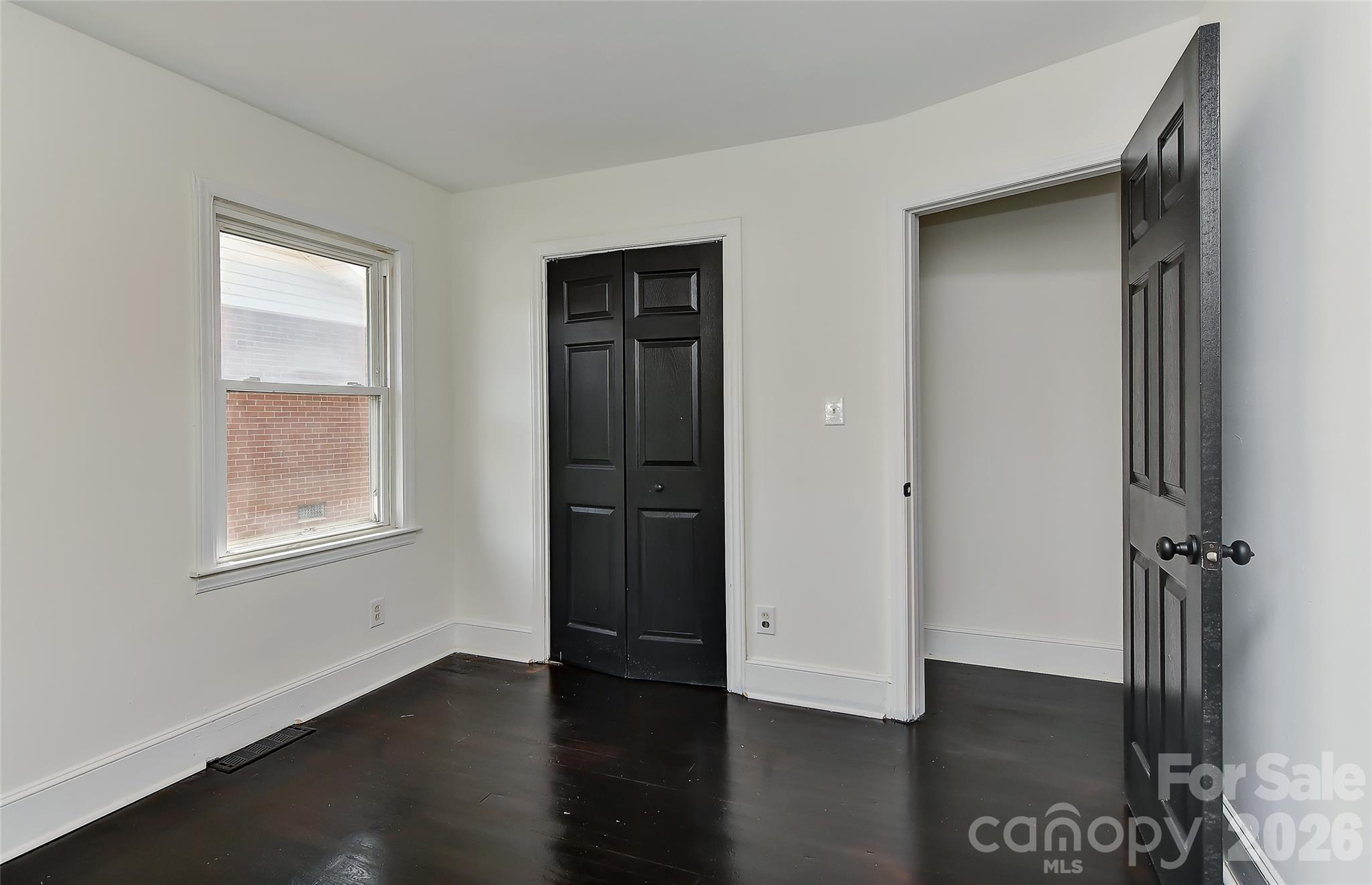 961 Clanton Road Charlotte, NC 28217 - Photo 13 of 23 a view of an empty room with wooden floor and a window