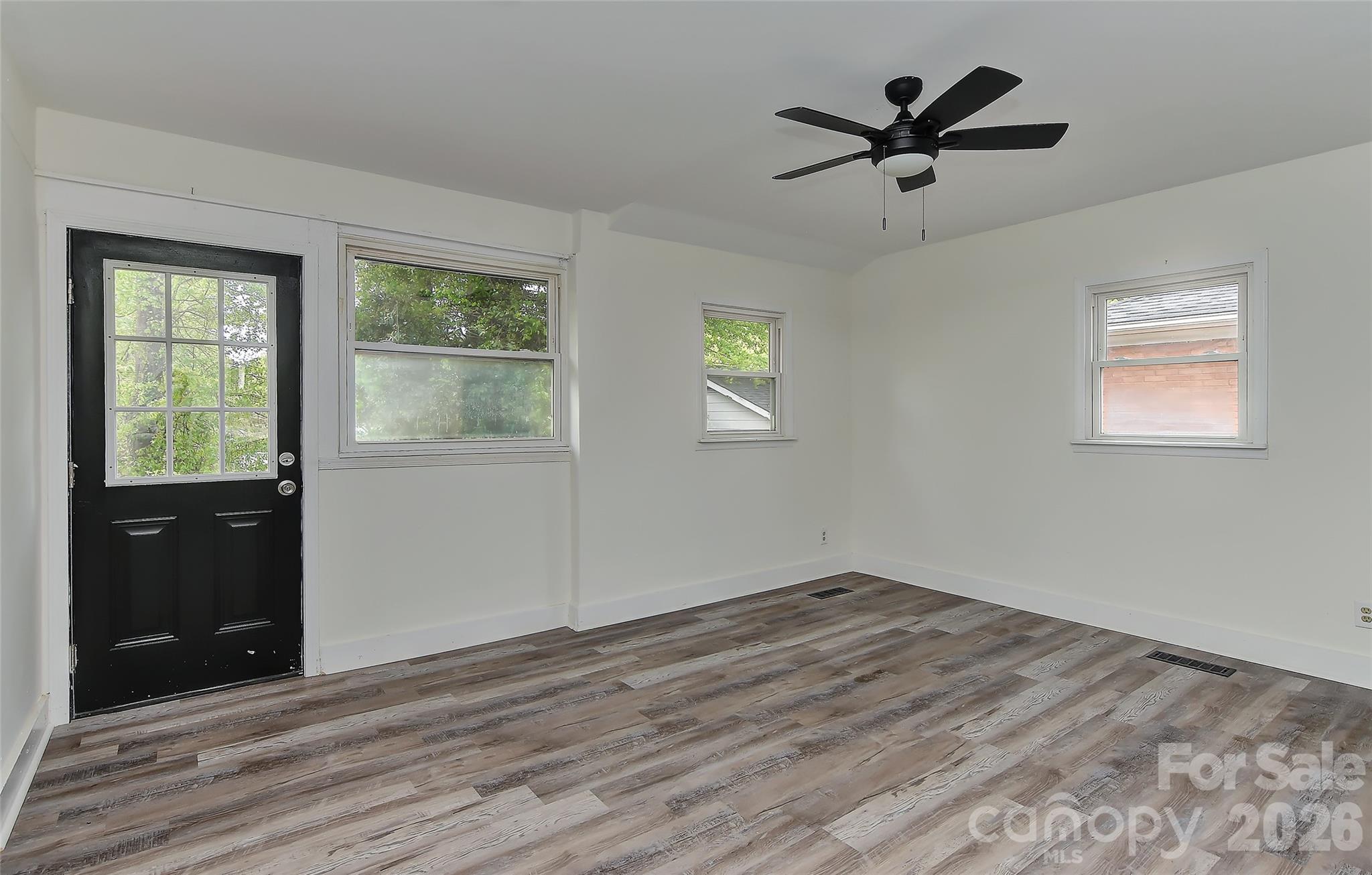 961 Clanton Road Charlotte, NC 28217 - Photo 20 of 23 a view of empty room with wooden floor and fan