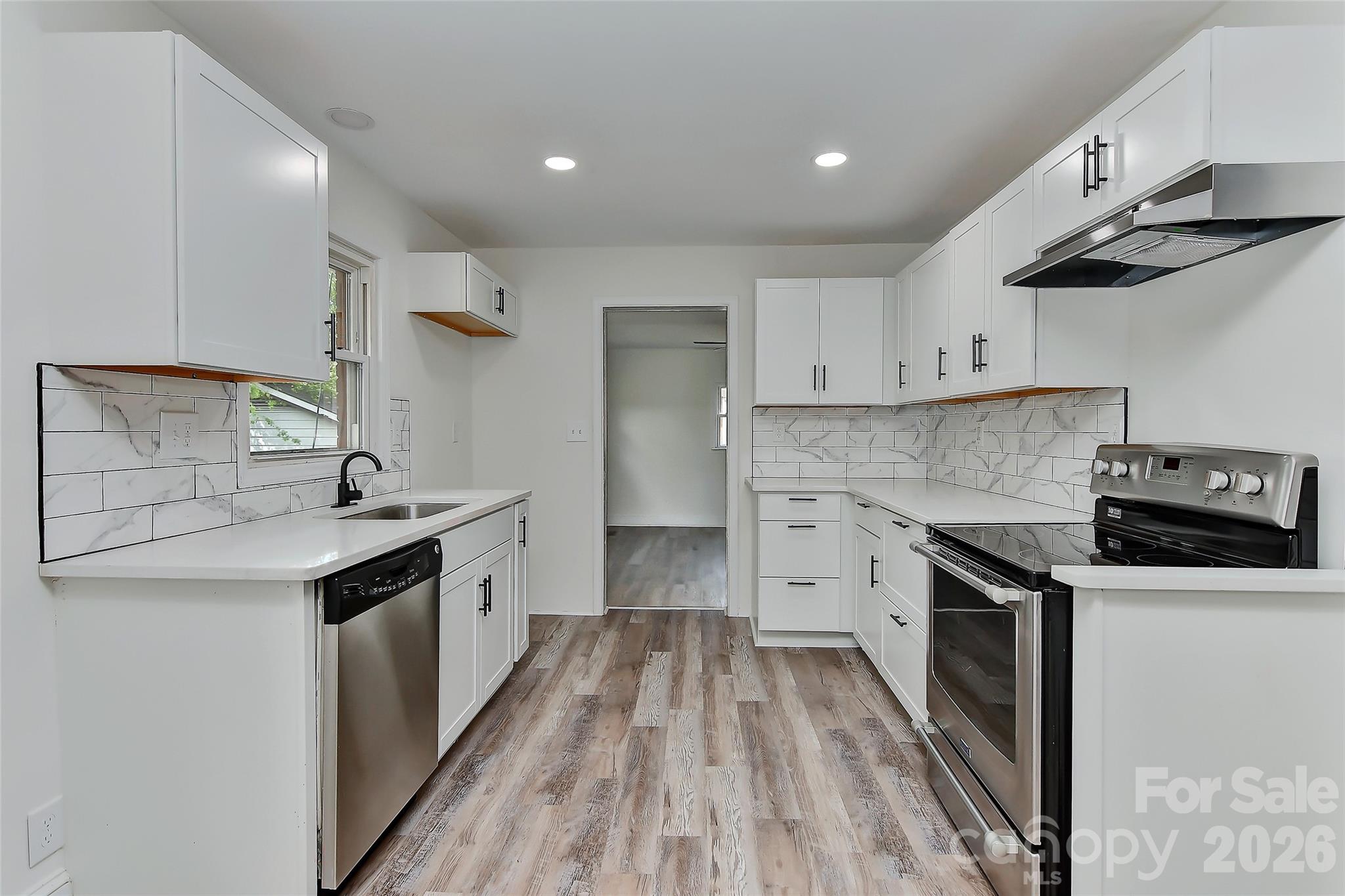 961 Clanton Road Charlotte, NC 28217 - Photo 2 of 23 a kitchen with granite countertop a sink stove and cabinets