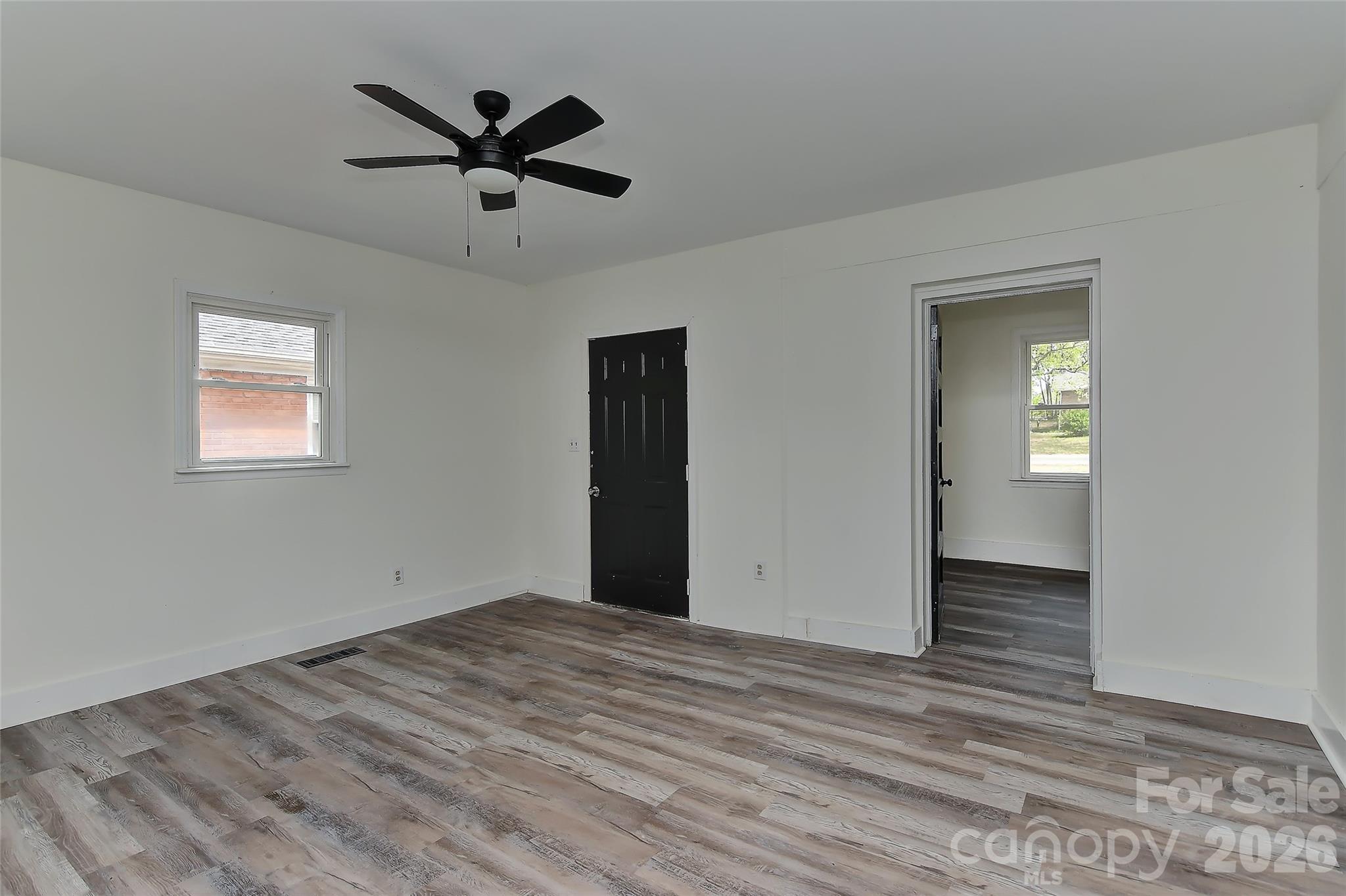 961 Clanton Road Charlotte, NC 28217 - Photo 21 of 23 a view of empty room with wooden floor and ceiling fan