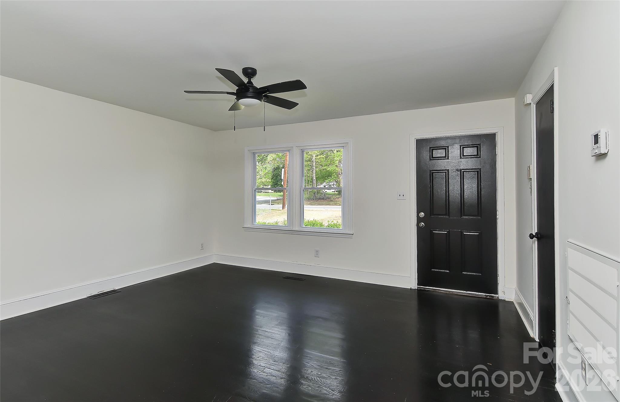 961 Clanton Road Charlotte, NC 28217 - Photo 5 of 23 an empty room with wooden floor closet and windows